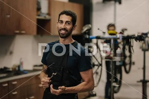 Workers repairing bicycles in workshop Stock Photos