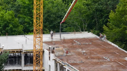 Workers resting on roof edge during concrete pouring process break. Stock Footage 346372433