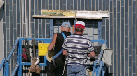 Workers restoring buildings fill window sills and extend protective products Stock Footage 49457731
