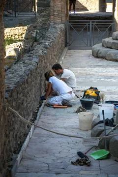 Workers restoring stone wall in the ruins of Pompeii Stockfoto's