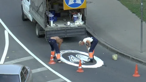 Workers on the road draw traffic sign with white dye Stock Footage 95325912