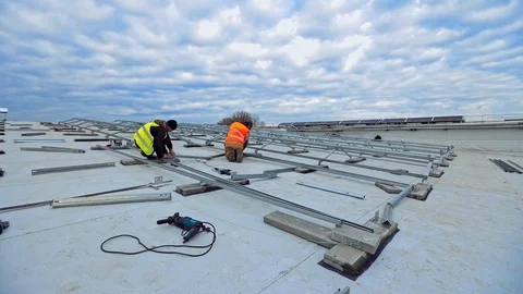 Workers on the roof of flat building. Engineers installing metal basis  Stock Footage 128240371