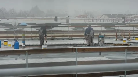 Workers on the roof working with fire under rain Stock Footage 145471215