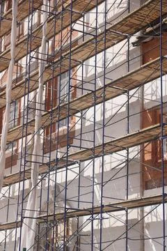 Workers on scaffolding at the construction site of a new building 2 Stock Photos