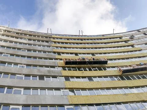 Workers on the scaffolding working on the thermal insulation of a building in Stockfoto's