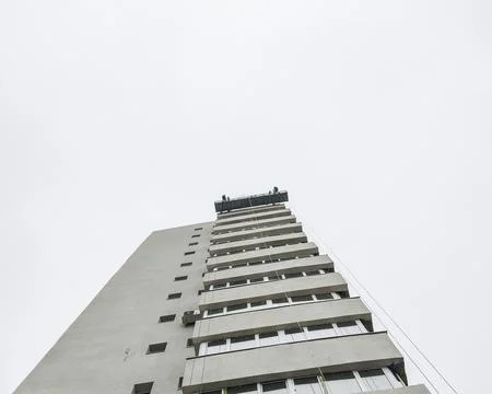 Workers on the scaffolding working on the thermal insulation of a building in Fotos Stock