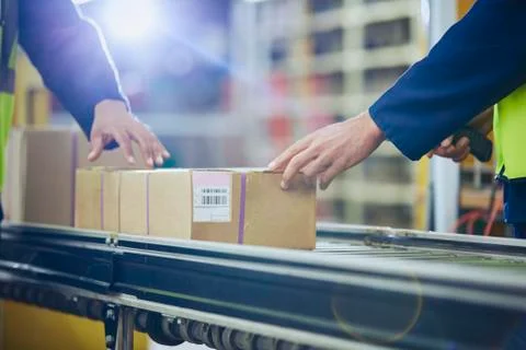 Workers scanning and processing boxes on conveyor belt in distribution warehouse 写真素材