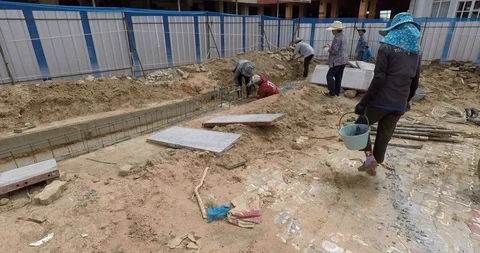 Workers secure a metal frame with wire on a building construction site Stock Footage 94095311