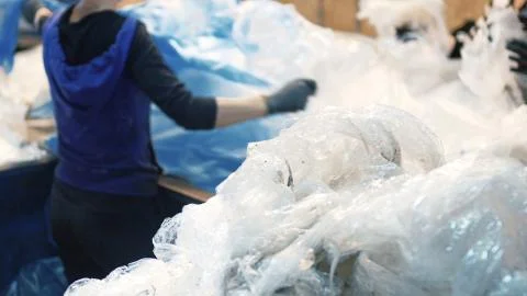 Workers select and sort garbage that travels on a conveyor belt in a waste Фото