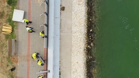 Workers set up a mobile dam on the riverbank against the the flood. 動画素材 121312874