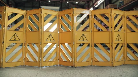 Workers setting up expandable safety barrier in industrial area Stock Footage 309324296