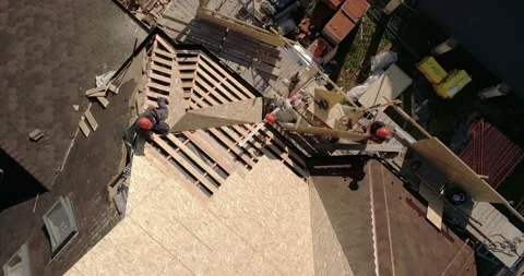 Workers setting roof panel on the cottage under construction 動画素材 140888325