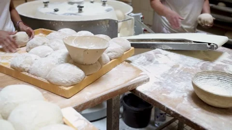 Workers shaping dough using a round dough molder in a bakery Stock Footage 284555960