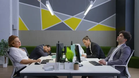 Workers sitting at tables bored, tired, waiting for the end of the working day Stock Footage 233994330