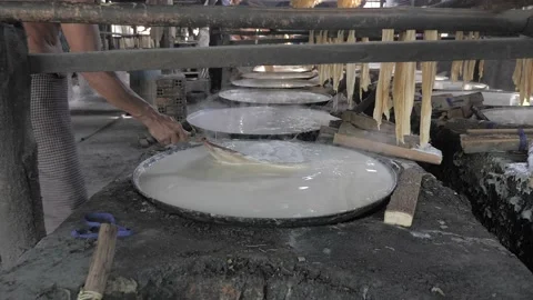 Workers skim up the foam forms on the surface during the boiling of soy milk Stock Footage 165983368