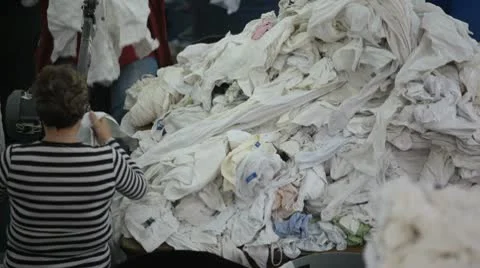 Workers sort and cut material in textile recycle factory. Stock Footage 8995370