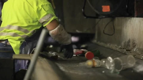 Workers sort trash on a conveyor belt at a recycling center. Stock Footage 8524337