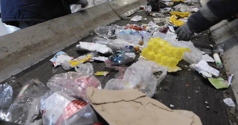 Workers sorting garbage on moving conveyor belt at recycling plant for reuse. Stock Footage 120123639