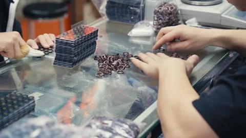 Workers sorting smartphone components camera module metal rings on factory Stock Footage 328950365