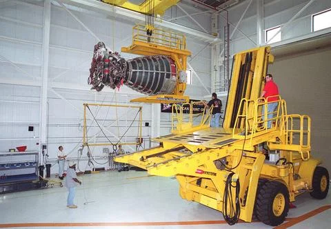 Workers in the Space Shuttle Main Engine Processing Facility oversee the m... Stock Photos