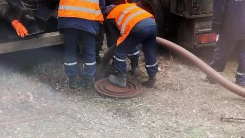 Workers in special clothing and special tools remove blockages in the sewer. A Video stock 304960257