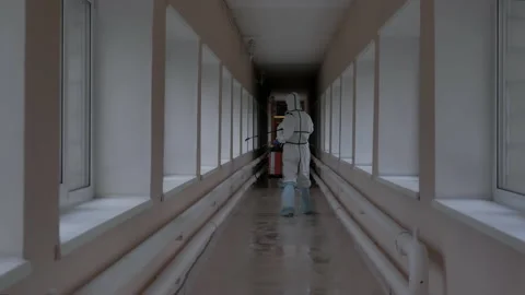 Workers spray a disinfectant solution in an elevated passage Видео 131461262
