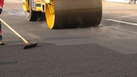 Workers stacking asphalt with roller Stock Footage 122096014