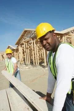 Workers Stacking Boards At Construction Site Stock Photos
