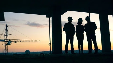 Workers stand on a building site, talking. Construction workers at modern Video stock 117632905