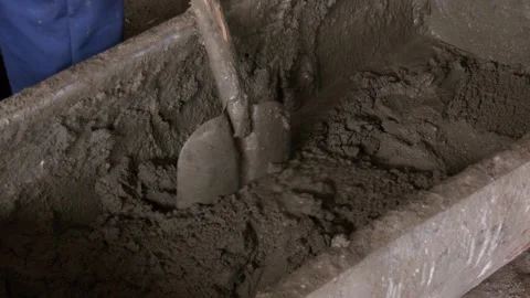 Workers stir or mix cement with shovels at construction site. Video stock 316515282