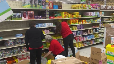 Workers Stock Shelves with Easter Candy Stock Footage 170465602