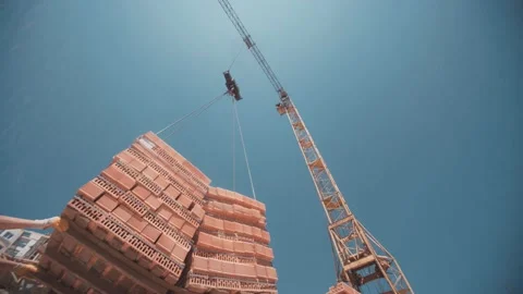 Workers stuck a red bricks blocks lifted by a crane Stock Footage 143193971
