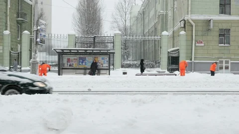 Workers sweep snow from sidewalk in winter, Cleaning sidewalk from snow storm Stock Footage 99370629