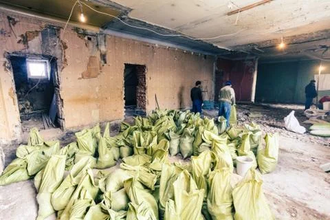 Workers take away construction garbage and waste  from dismantling in bags fo Stock Photos