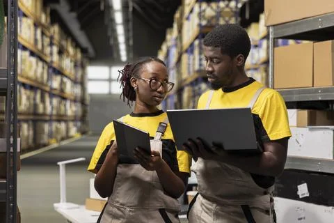Workers team in overalls documenting inventory in an industrial warehouse Foto stock