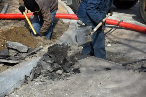 Workers throw sand with shovels. Stock Photos