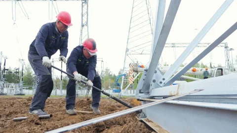 Workers tighten large bolt with tool on metal beam at building site Stock Footage 93263562
