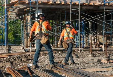 Workers transporting metal rods Stock-Fotos