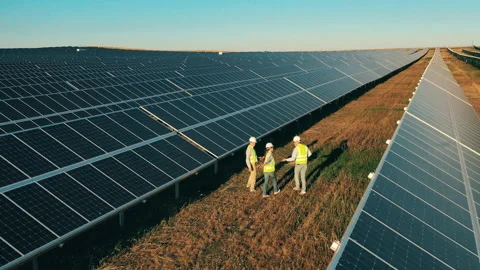 Workers in uniform and helmets performing inspection at solar farm Stock Footage 142207635