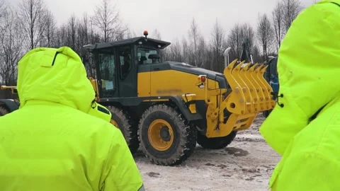 Workers in uniform on background of working grader. Heavy construction equipment 스톡 동영상 154430207