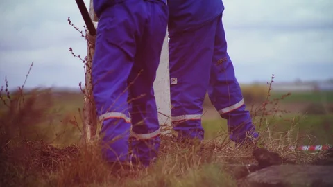 Workers in uniform fill up pit for post on windy day closeup Video stock 127757349