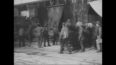 Workers unload and sort various kinds of supplies on docks - 1918 Stock Footage 98950445