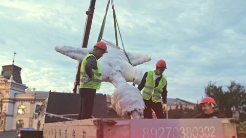 Workers unload concrete star from cargo platform with truck crane Vídeo Stock 258468623