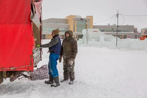 Workers unloading ice blocks into a car Fotos Stock