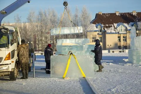 Workers unloading ice blocks from a car 스톡 사진