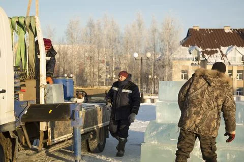 Workers unloading ice blocks from a car 스톡 사진
