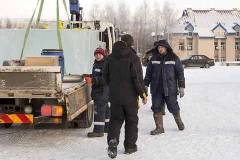 Workers unloading ice blocks from a car 스톡 사진