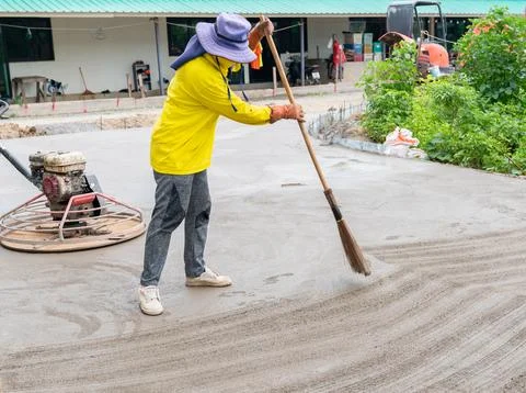 Workers use brooms to make marks to make the concrete road surface. Stock-Fotos