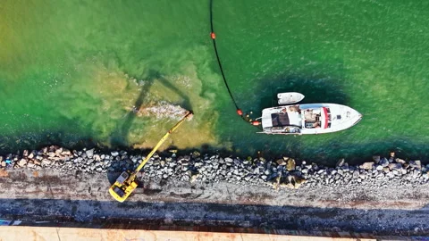 Workers use a crane and a boat to help with maintenance tasks along the Stock Footage 331333003