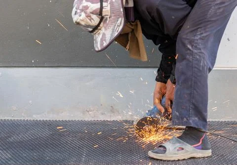 Workers use electric grinding machine cutting metal grill. Stock-Fotos